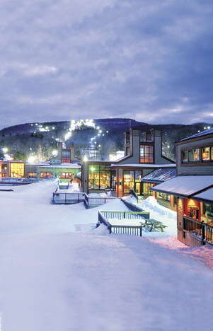 Outside a ski resort with snow on the ground and an overcast sky in the evening